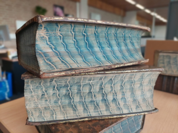 De snedes van deze twee boeken zijn bewerkt met een blauwe kleur stijfselmarmer