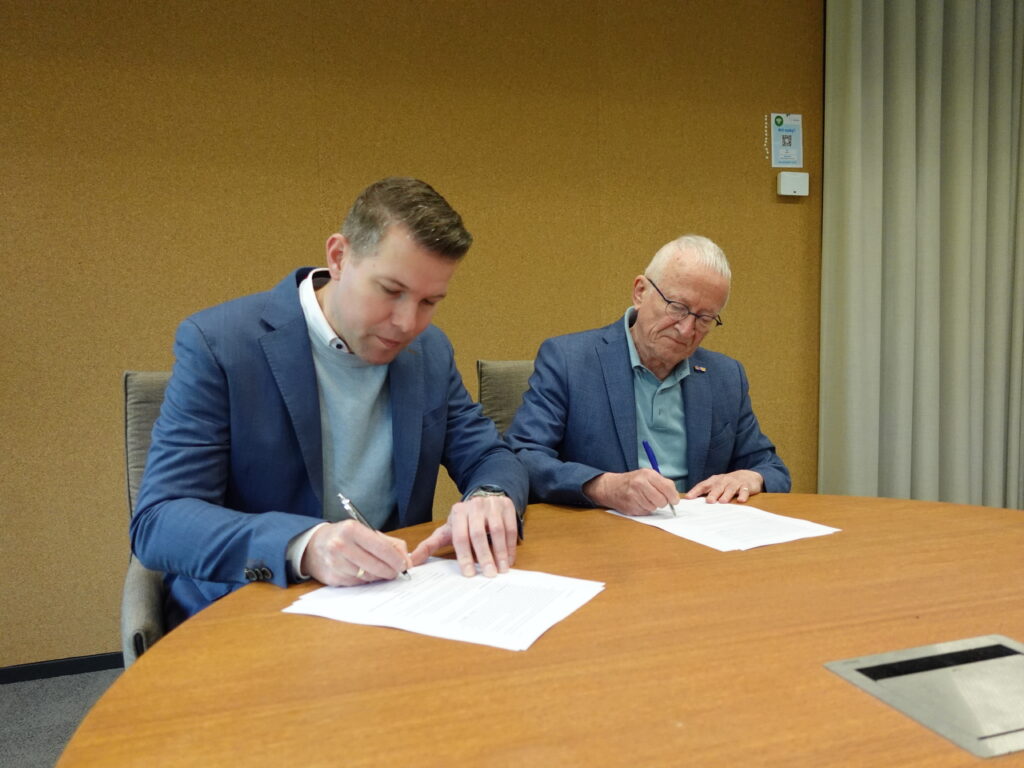 Alex Kleijnen, voorzitter van de Vereniging Historisch Ermelo en Rudolf Bosch, directeur NoVA ondertekenen de overeenkomst voor de samenwerking tussen de Vereniging Historisch Ermeloo en Noord-Veluws Archief.