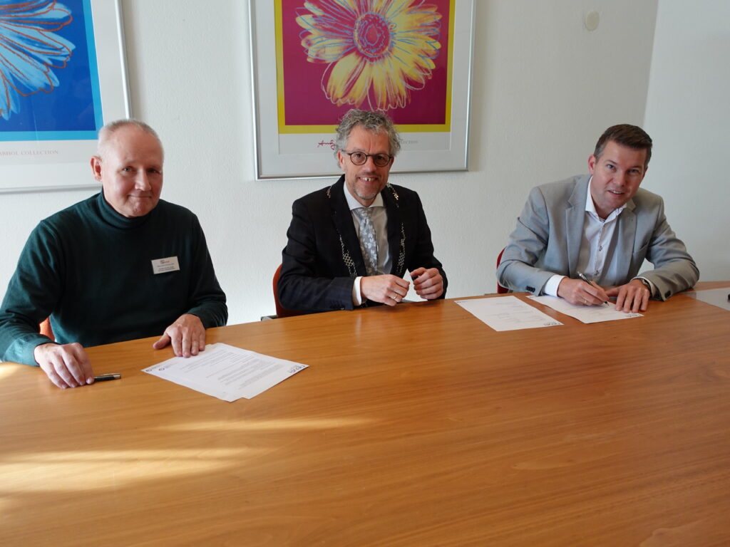 Douwe van der Heide (GGz Centraal), Burgemeester Hans van Daalen en Rudolf Bosch (Noord-Veluws Archief) en tekenen de overeenkomst