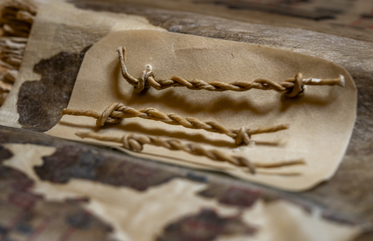 Een closeup foto van strengels in een middeleeuwse boekband.