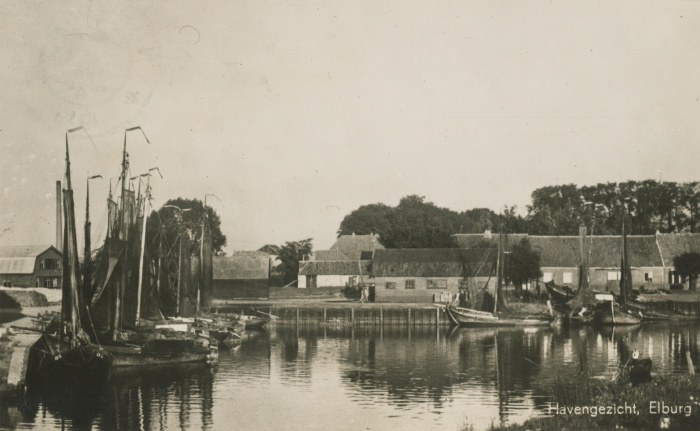 Een zwart/wit foto van boten liggend in he water. Op de achtergrond huizen. Als tekst staat er op: Havengezicht, Elburg.